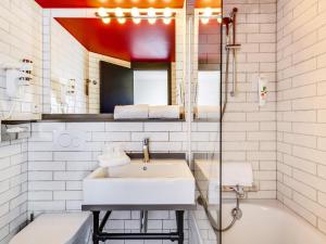 a white bathroom with a sink and a bath tub at Ibis Styles Paris Saint Denis La Plaine in Saint-Denis +41 photos