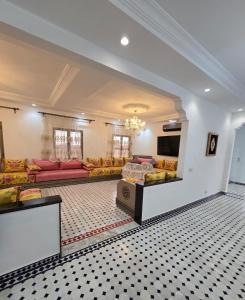 a large living room with couches and a tv at Riad Gogo in Aït Ben Haddou