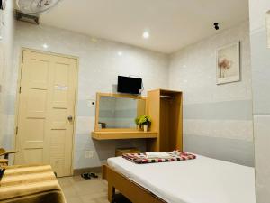 Habitación con cama y TV en la pared. en Motel Mốt, en Da Nang