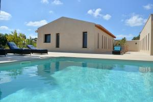 a villa with a swimming pool in front of a house at Finca Sol y Mar Es Trenc in Campos