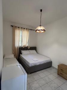 Darëzeza e ReVjosa River Rooms的一间卧室，配有两张床、一台冰箱和一盏吊灯