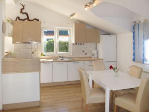 a kitchen with a white table and a white table and chairs at Apartment Marin in Grebaštica