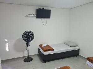 a small bedroom with a bed and a fan at Hotel Rei in São Bernardo do Campo