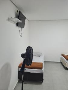 a room with a fan and a room with two beds at Hotel Rei in São Bernardo do Campo