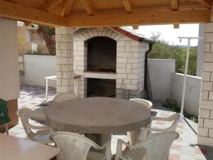 a patio with a table and chairs and a pizza oven at Apartment Joso in Primošten