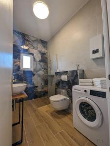 a bathroom with a washing machine and a sink at Apartment Joso in Primošten