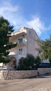a tall building with a stone wall in front of it at Apartment Nana in Primošten