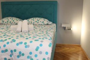 a bedroom with a bed with a green headboard and pillows at Apartment Nana in Primošten