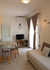 a living room with a bed and a table and a television at Apartment Nana in Primošten