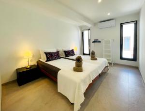 a bedroom with a large bed and two windows at Finca Sol y Mar Es Trenc in Campos +88 photos