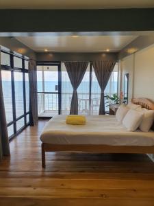 a bedroom with a large bed with a view of the ocean at Casita Del Mar Palawan - Beachfront Room in Puerto Princesa City