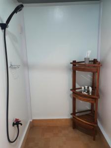 a shower in a room with a wooden shelf at Casita Del Mar Palawan - Beachfront Room in Puerto Princesa City