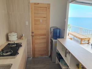 a kitchen with a view of the ocean at Casita Del Mar Palawan - Beachfront Room in Puerto Princesa City +21 photos