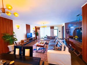 a living room with a couch and a table at 1404 Roseville Family Stays - Heated Rooftop Pool, Kids Play, Garden in Nairobi
