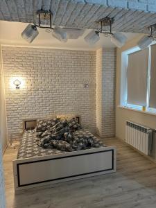 a bed in a room with a brick wall at Kachanivska apartments in Kharkiv