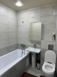 a bathroom with a toilet and a tub and a sink at Kachanivska apartments in Kharkiv