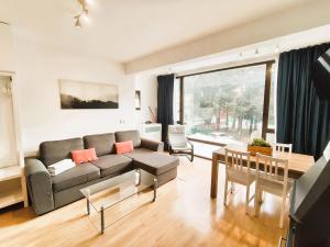 una sala de estar con un sofá y una mesa en SKI & SNOW APARTMENTS - PLAZA DE PRADOLLANO - Junto a los Telecabinas by TODOSIERRANEVADA, en Sierra Nevada