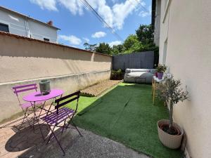 un piccolo cortile con un tavolo e delle sedie rosa di Majorelle Studio near Eurexpo - Lyon - hospitals a Bron