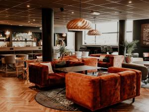 un vestíbulo con sofás y mesas y un bar en Mercure Valenciennes Centre, en Valenciennes