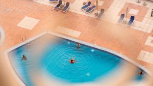 an overhead view of people swimming in a pool at Royal Breeze Sea View One Bedroom Apartment in Ras al Khaimah