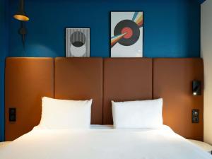 a bedroom with a large bed with two pillows at ibis Paris Gare de Lyon Reuilly in Paris