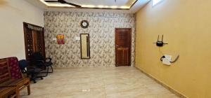 a hallway with a door and a clock on a wall at Lavanya Regency Floor Kanchipuram in Kanchipuram