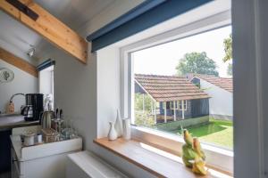 a kitchen window with a view of a house at De Heerlijkheid in Groenlo
