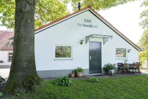 a white building with a sign on the side of it at De Heerlijkheid in Groenlo