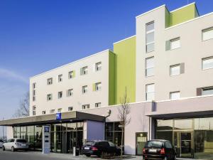 a building with cars parked in front of it at Ibis budget München Airport Erding in Erding