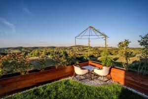a patio with a table and chairs and a view at Casa Deluxe in Sinteu - intersectia intre modern si linistea naturii in Şinteu