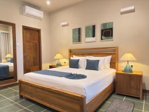 a bedroom with a large bed and two lamps at Casa Tartaruga in Unawatuna