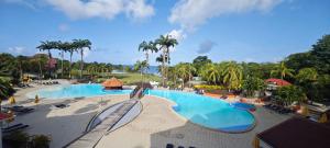 a view of the pool at a resort with palm trees at Studio Saint Vincent 13 in Sainte-Luce