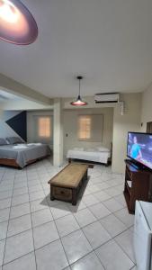 a large room with two beds and a tv at Vinte Park Hotel in Bragança Paulista