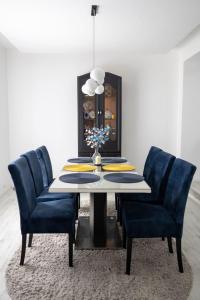 une salle à manger avec une table et des chaises bleues dans l'établissement Una Riverside Heritage House, à Bihać