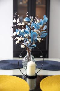 un vase avec des fleurs bleues et une bougie sur une table dans l'établissement Una Riverside Heritage House, à Bihać