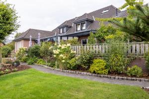 a house with a fence and a garden at Ferienwohnungen Schoofs in Kalkar