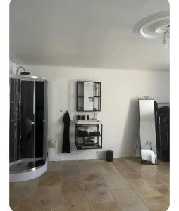 a white room with a mirror and a black refrigerator at Maison 1838 