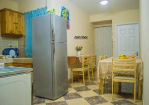 une cuisine avec un réfrigérateur en acier inoxydable et une table dans l'établissement Villa 9BR, à Flic-en-Flac