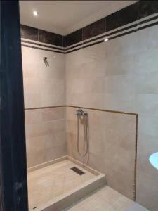 a bathroom with a shower with a tub and a sink at Appartement de standing centre harhoura in Temara