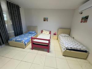 a room with two beds and a chair in it at Bujtina Gashi Relax Nature 