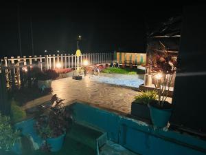 a backyard at night with a fence and a pool at Tea vista holiday home in Kalpetta