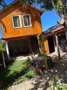 a log cabin with a porch and a staircase in front of it at Bujtina Gashi Relax Nature 