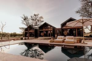 オチワロンゴにあるOtjiwa Savanna Luxury Villaのプール付きの家