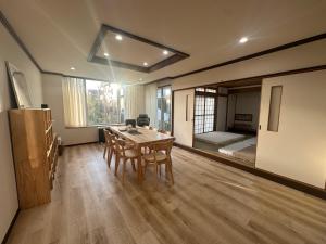 a room with a table and chairs and a bedroom at Teine blue house手稻藍房子 in Sapporo