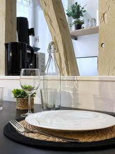 a table with a plate and a wine glass at Studio Cosy & bohème - Quartier Cauchoise in Rouen