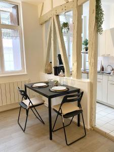 a black table and chairs in a kitchen at Studio Cosy & bohème - Quartier Cauchoise in Rouen
