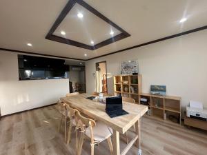 a dining room with a table with a laptop on it at Teine blue house手稻藍房子 in Sapporo