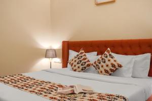 un letto con cuscini e un libro sopra di Dochi 4-BHK apartment with Hill Views, Living Room, & Balconies a Parwanoo