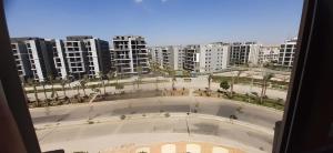 une vue depuis une fenêtre d'une ville avec de grands immeubles dans l'établissement Luxury 3 bed room apartment in rehab october city compound - modern open view luxury stay, à ‘Ezbet `Abd el-Ḥamîd