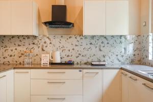 una cucina con armadi bianchi e carta da parati floreale di Dochi 4-BHK apartment with Hill Views, Living Room, & Balconies a Parwanoo Altre 10 foto